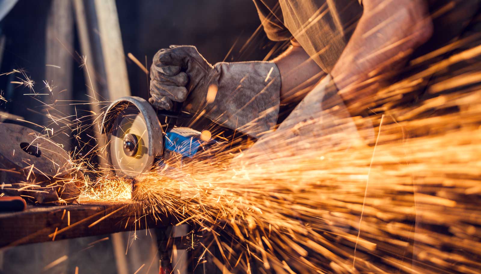 Close-up of worker cutting metal with grinder